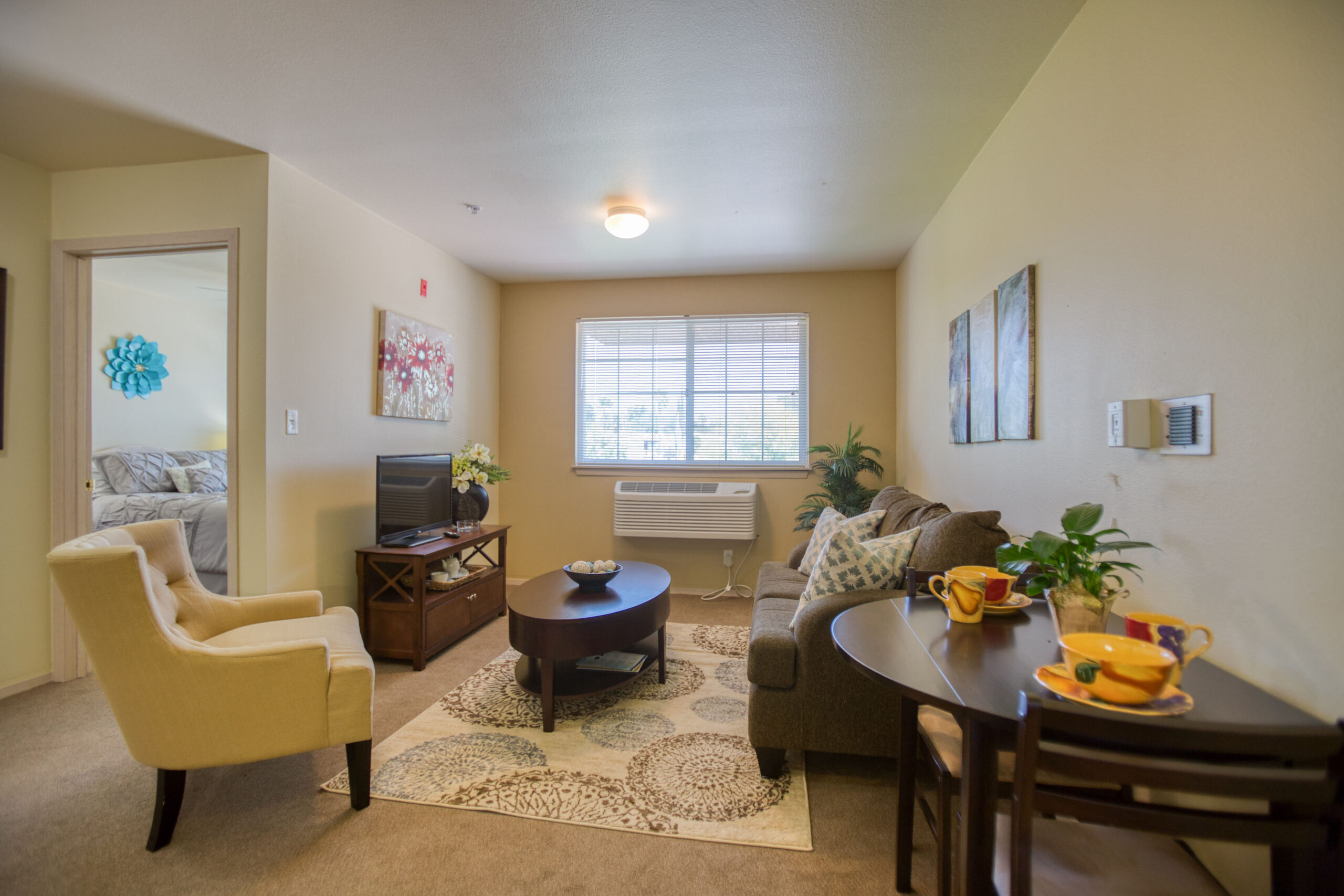 1175 S Abrego Dr - Green Valley - 40 - Vista Pointe at Green Valley Interior image of a Vista Pointe at Green Valley apartment with a living room, dining area, and peek into the bedroom.