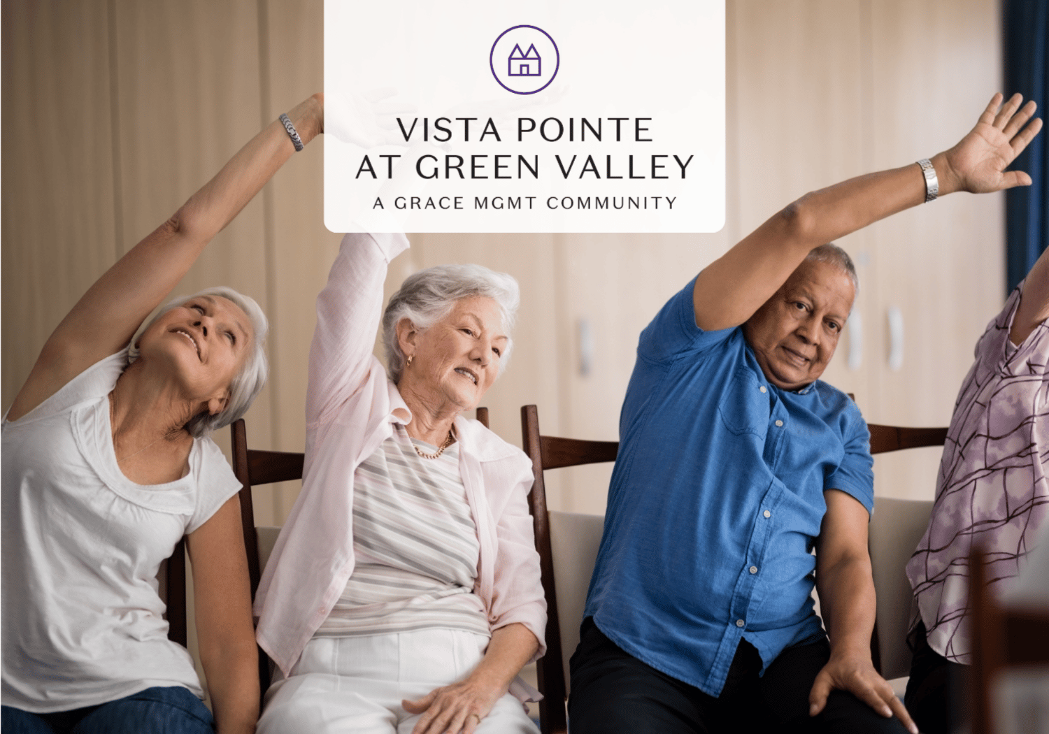 Seniors seated in a living room stretching their arms overhead as part of a group exercise, with a Vista Pointe at Green Valley banner above them.
